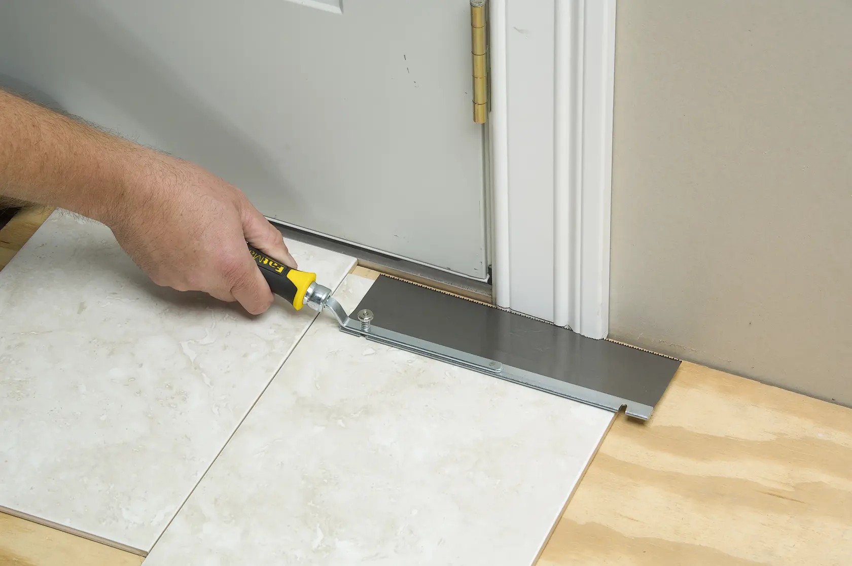 STANLEY 0-15-252 flooring saw cutting under door frame, straight angle view.