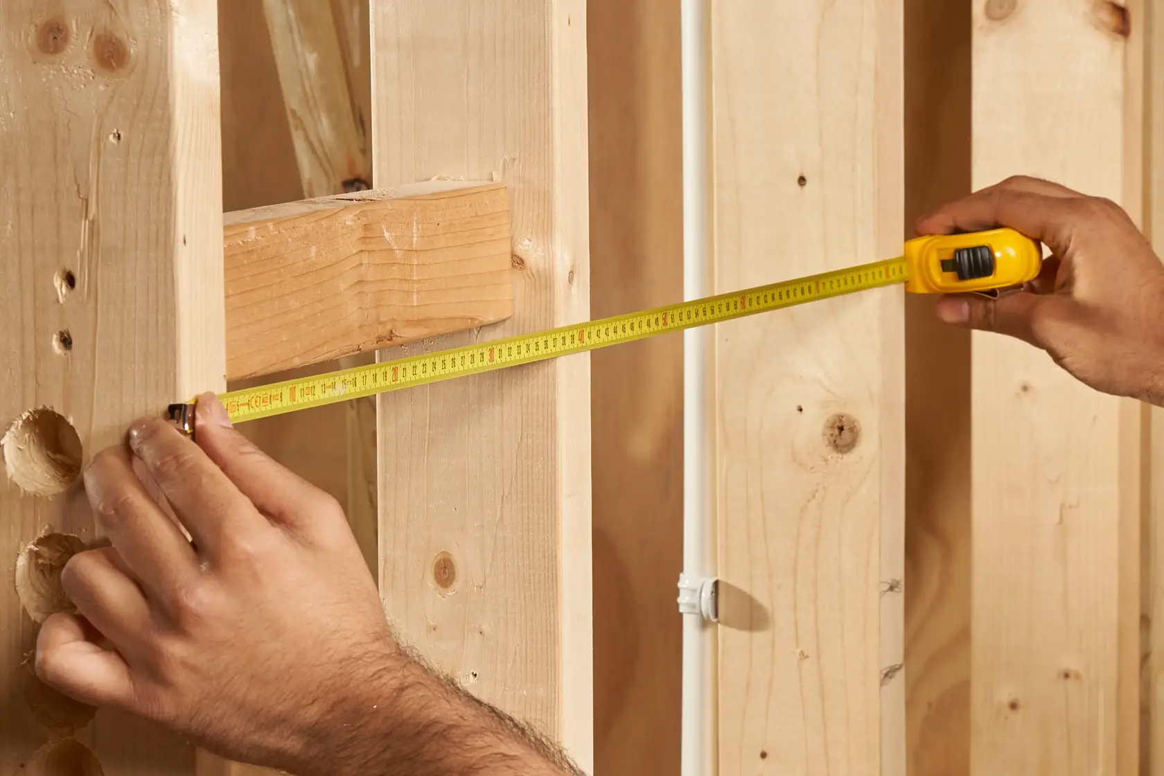 STANLEY 0-30-487 tape measure used for measuring wooden studs, close-up photography.