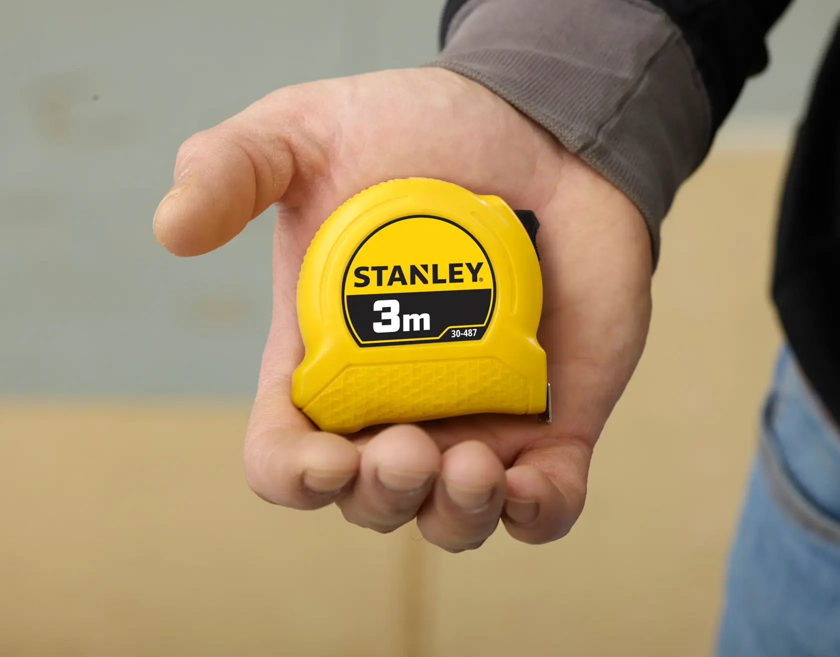 STANLEY 0-30-487 yellow 3m tape measure held in hand, clear product branding visible.