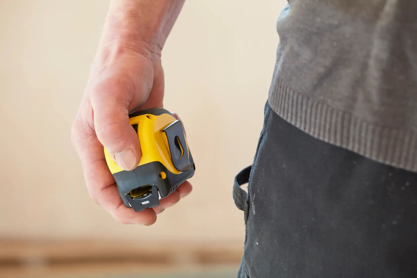 STANLEY 0-33-720 tape measure held in hand, close-up side view, yellow and black compact design.