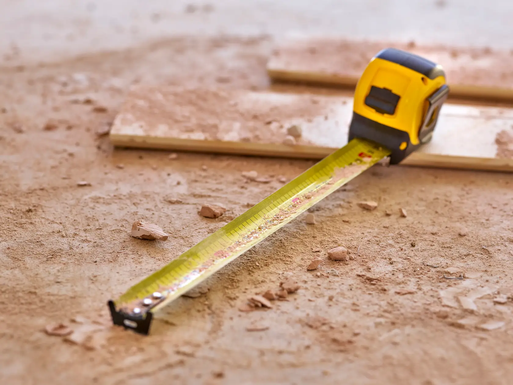 STANLEY 0-33-720 tape measure extended on a dusty worksite floor, yellow blade visible.