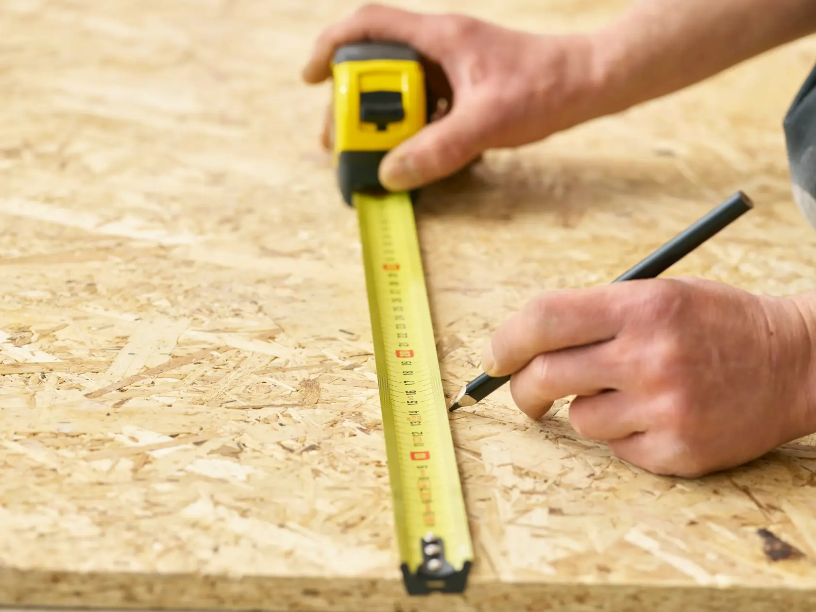 STANLEY 0-33-728 tape measure used to mark measurements on wood board, close-up photography.