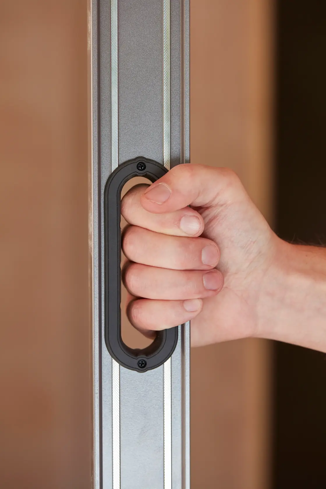 STANLEY 0-43-672 photography of hand holding aluminum level with black handle, side angle.