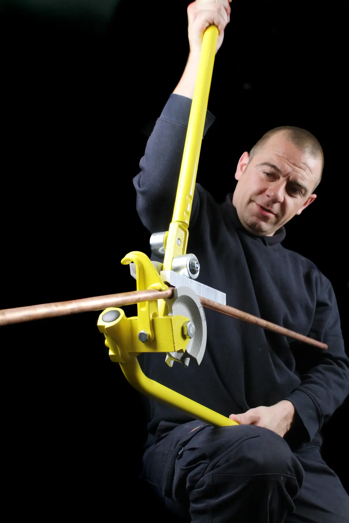 Photo of person using STANLEY 0-70-452 pipe bender on copper pipe, product action shot.