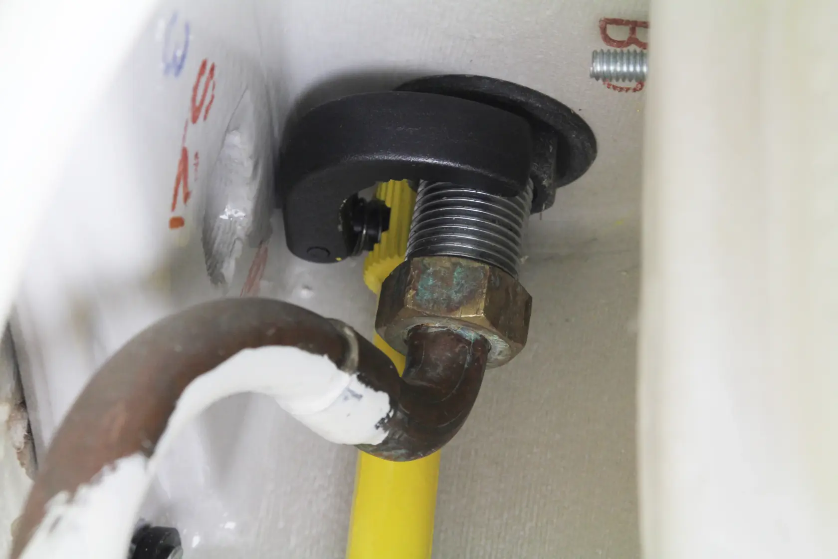STANLEY 0-70-453 pipe cutter close-up on metal pipe with threaded joint and yellow hose.