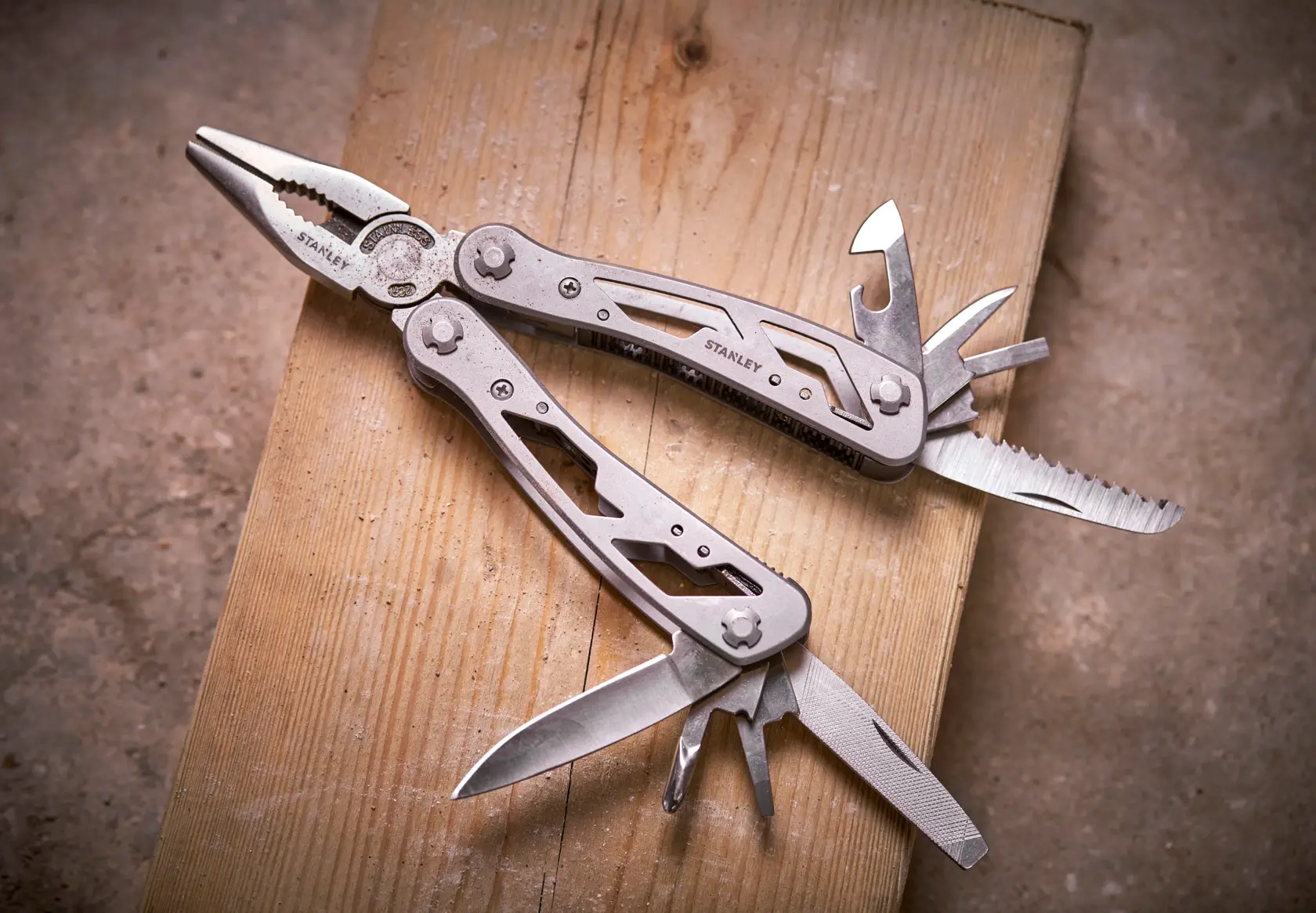 STANLEY 0-84-519 multi-tool with pliers and fold-out tools on wooden surface