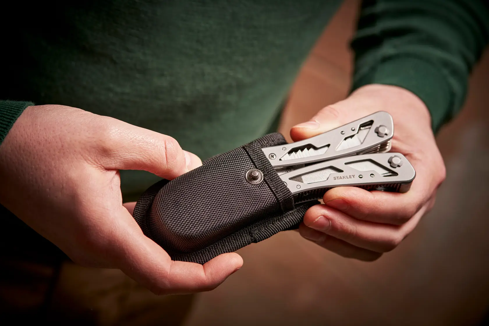 STANLEY 0-84-519 multitool in black case held in hands, close-up photo.