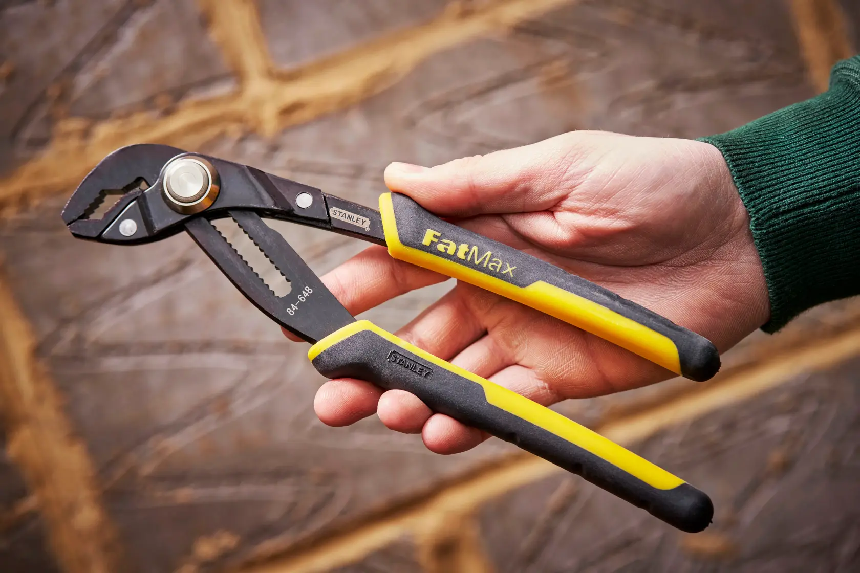 STANLEY 0-84-648 water pump pliers, FatMax, black and yellow handles, held in hand.