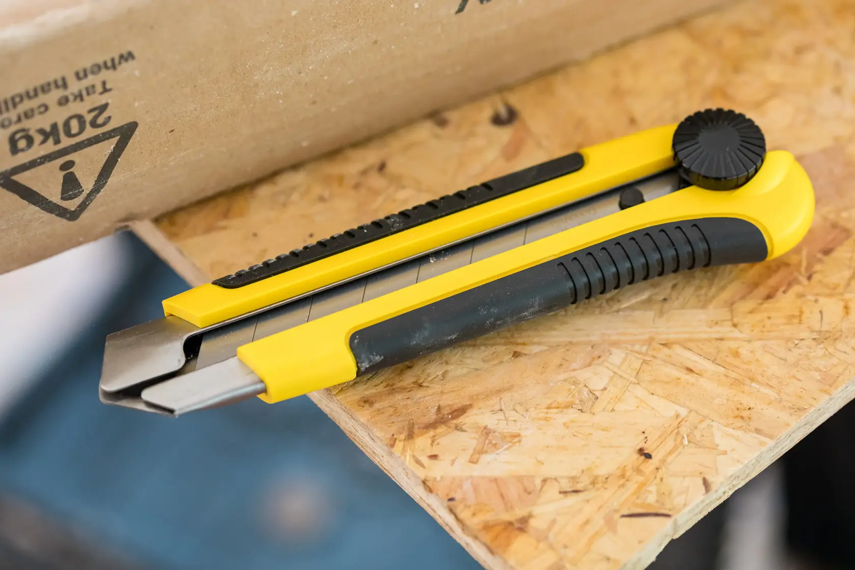 STANLEY 1-10-425 yellow and black utility knife on wooden surface, angled side view.
