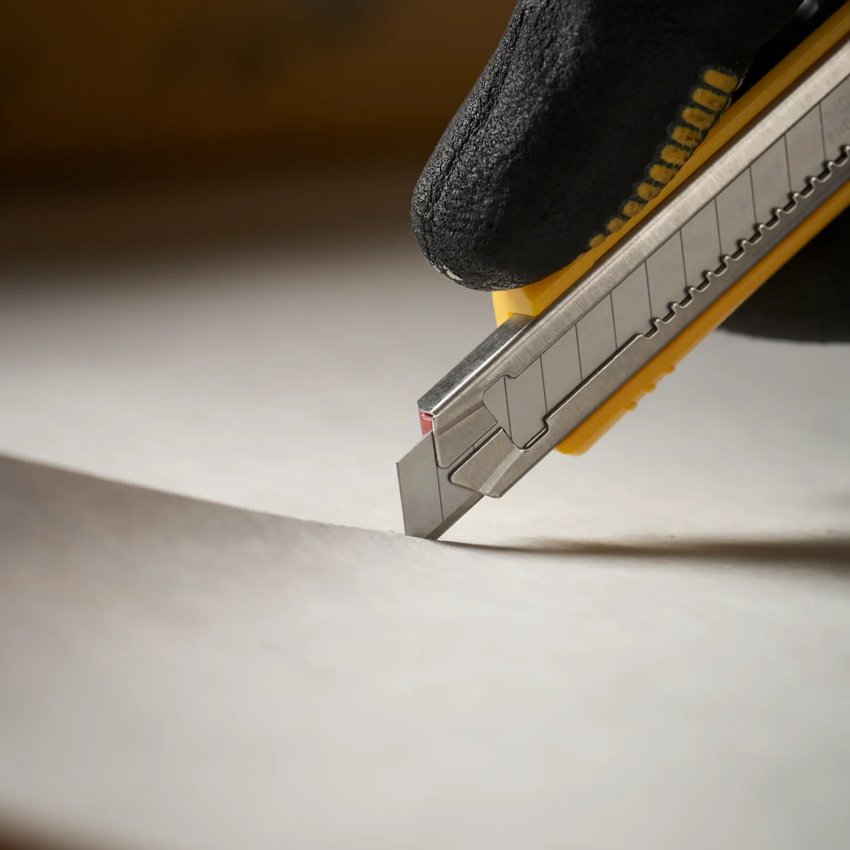 STANLEY 1-11-300 Universalmesser schneidet Papier, Nahaufnahme Seitenansicht, gelbes und silbernes Gehäuse, Fotografie.