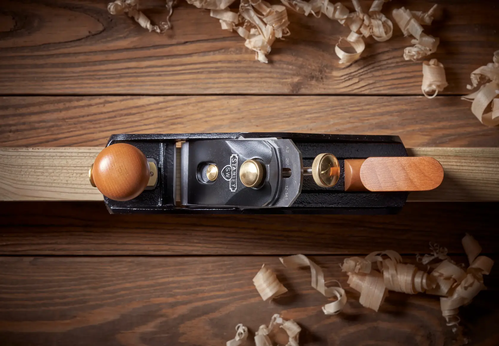 STANLEY 1-12-136 hand planer top view, wooden handle, on wood surface with shavings.