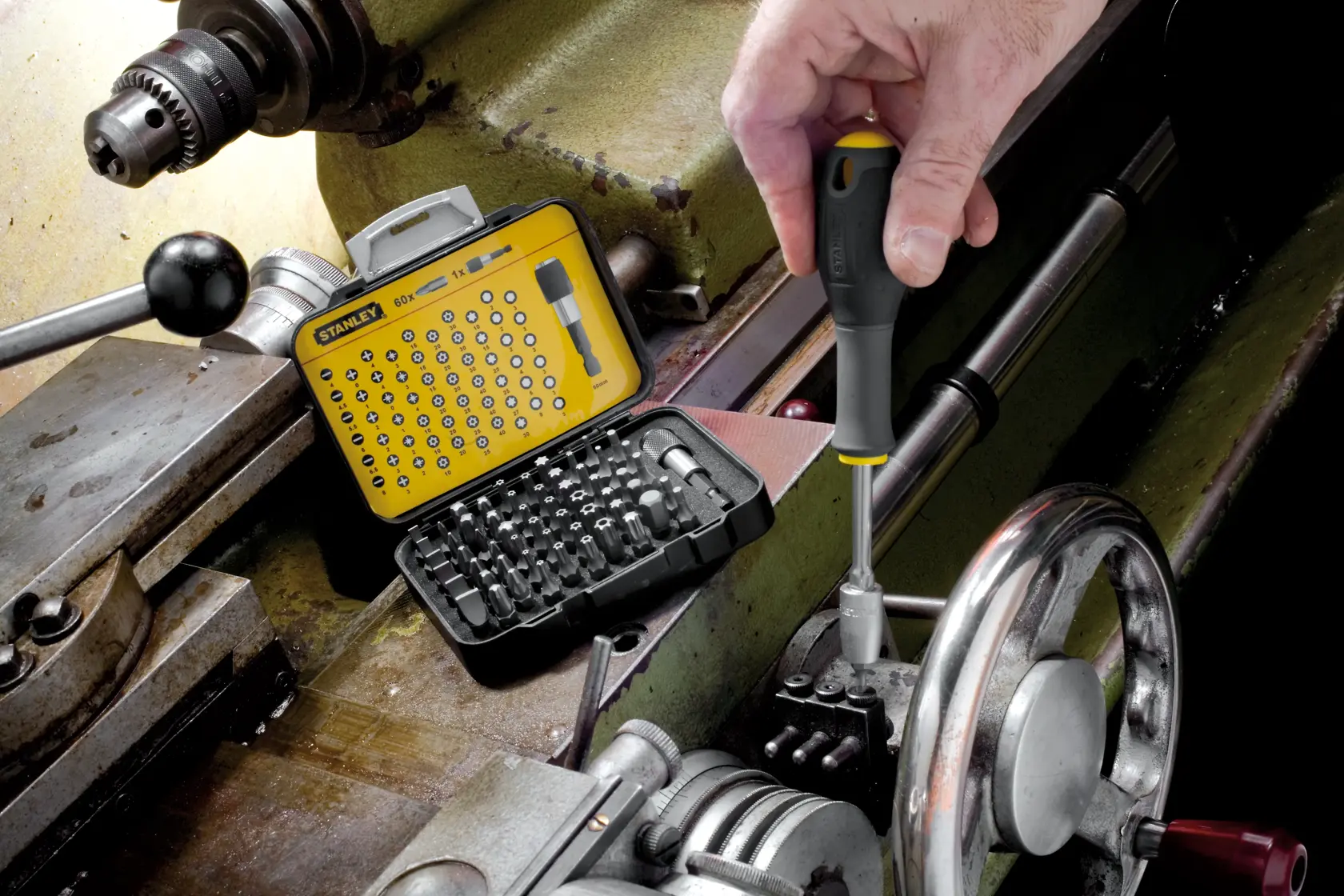 Stanley SKU 1-13-902 screwdriver bit set in yellow case used for machinery repair, close-up photography.