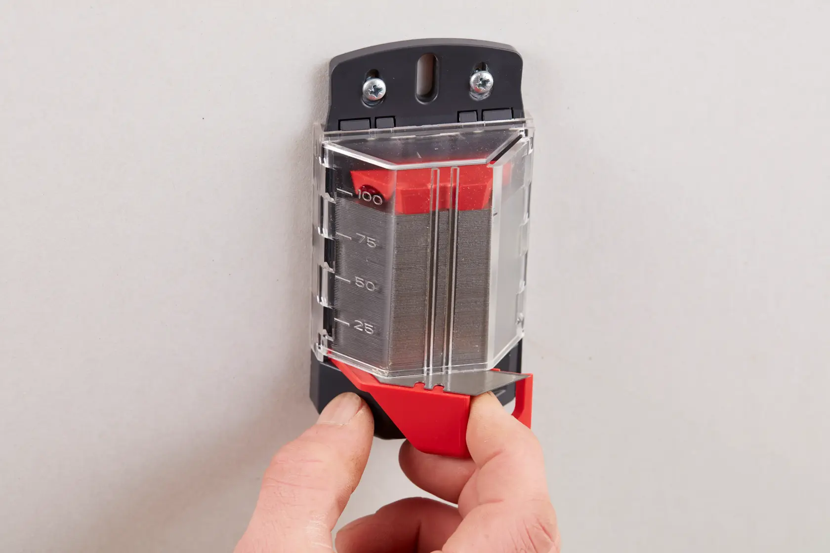 STANLEY 8-11-921 blade dispenser with clear cover and red slider, wall-mounted, front angle photo.