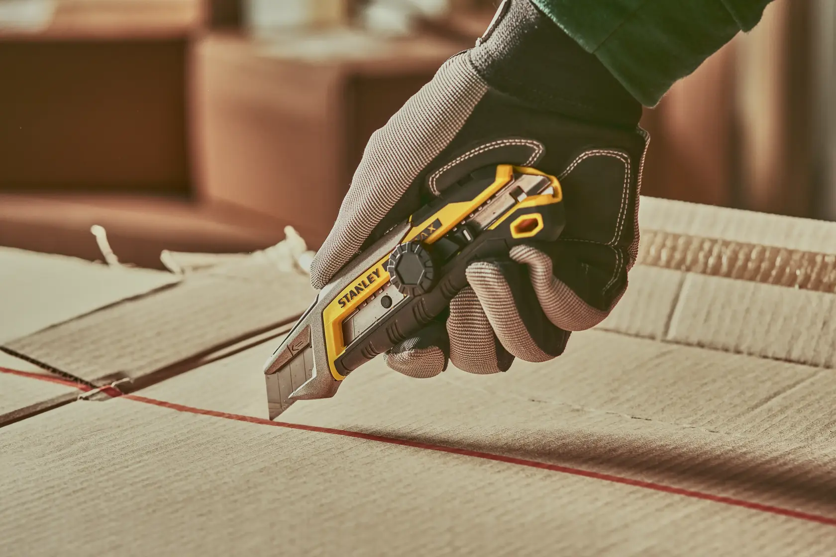 Photo of STANLEY FMHT10592-0 utility knife cutting cardboard, detailed side view in use.