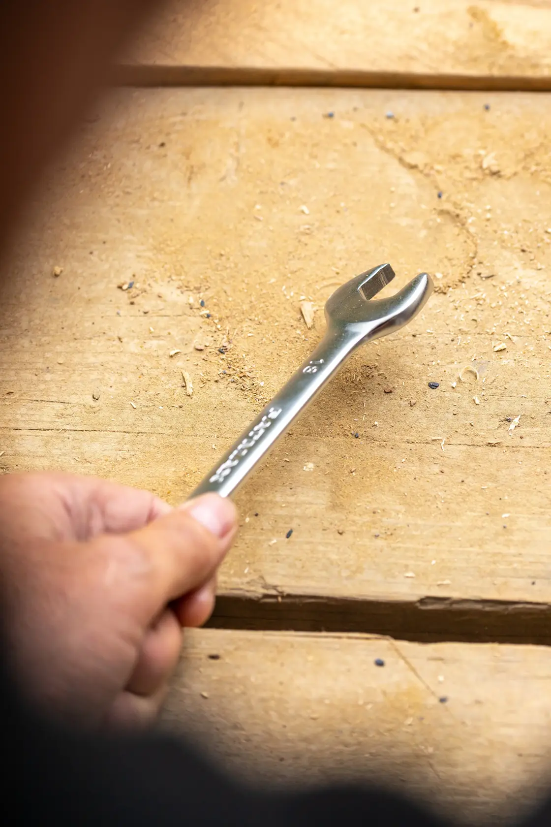 Stanley FMMT13071-0 wrench held by hand on a wooden surface, close-up photography.