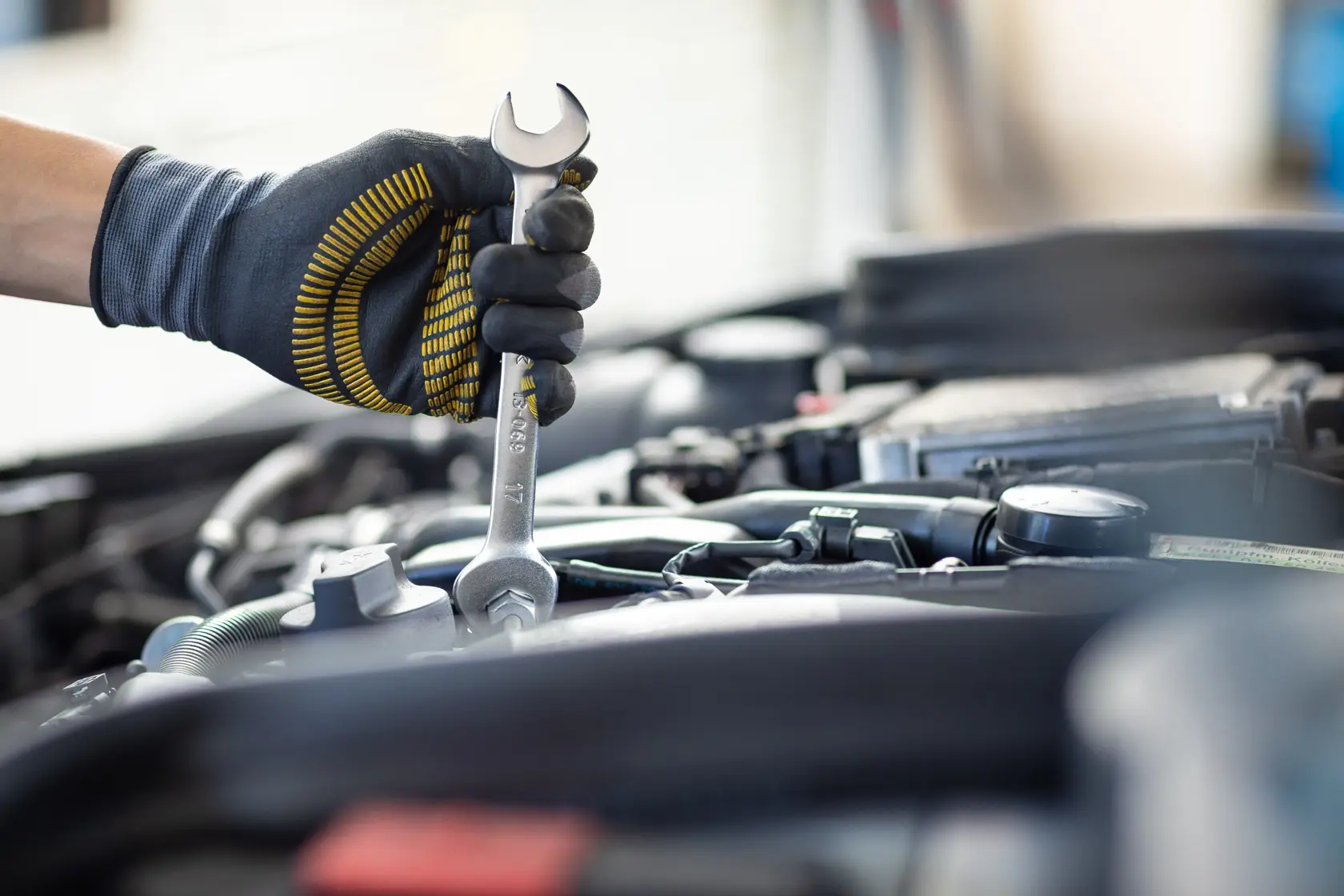 Photo of STANLEY FMMT13077-0 wrench in gloved hand tightening bolt in engine bay.