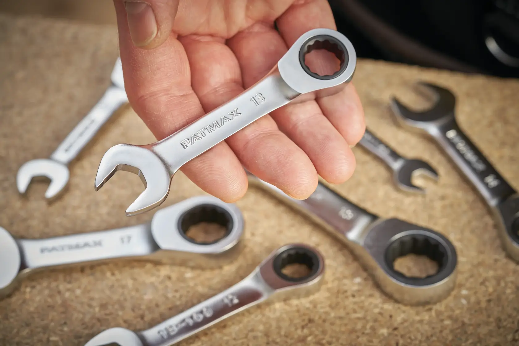 STANLEY FMMT13098-0 ratcheting combination spanner set, close-up with hand holding one wrench, other wrenches visible.