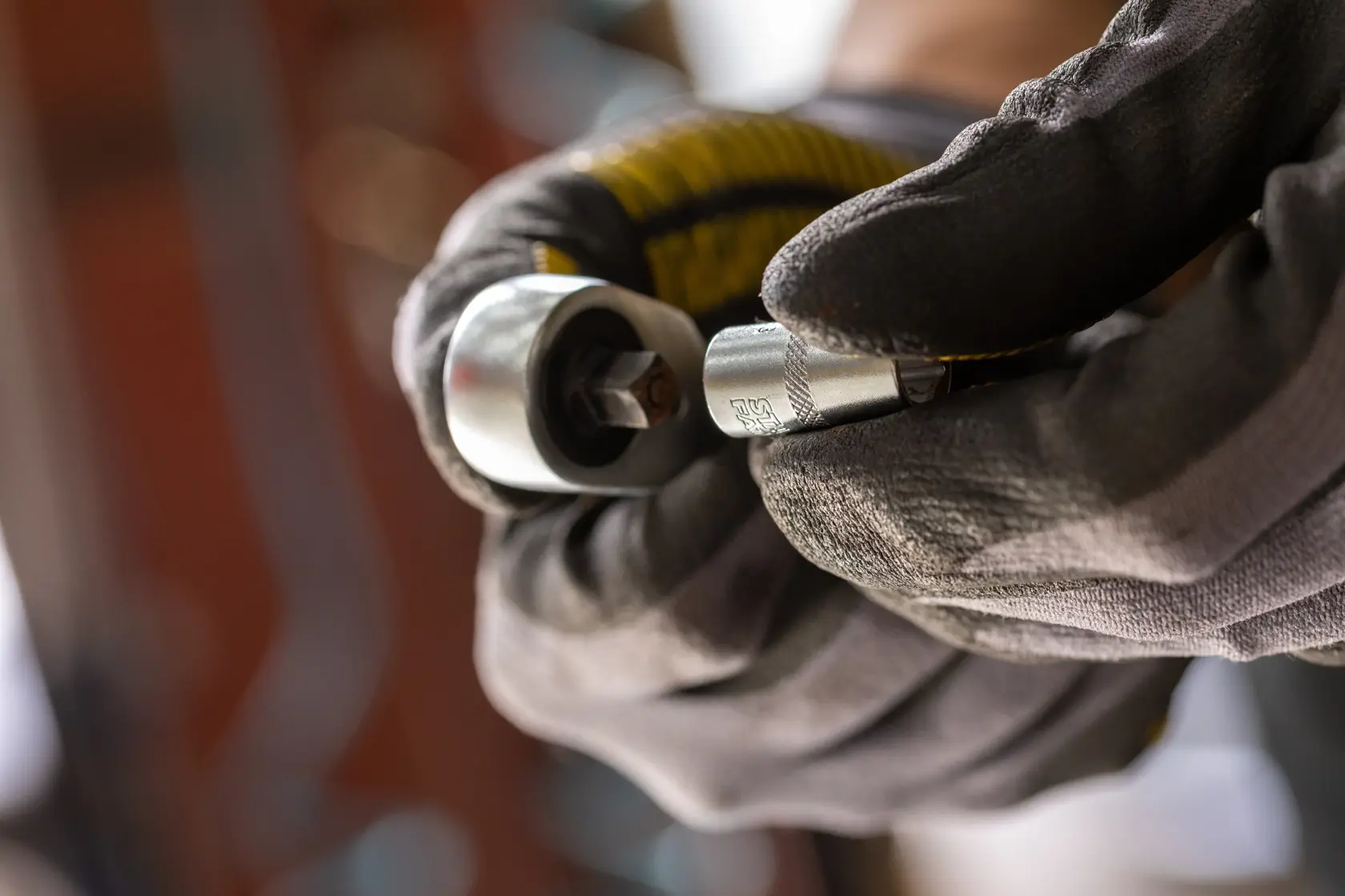 Photo of STANLEY FMMT17186-0 socket wrench tool held by gloved hands, close-up view.