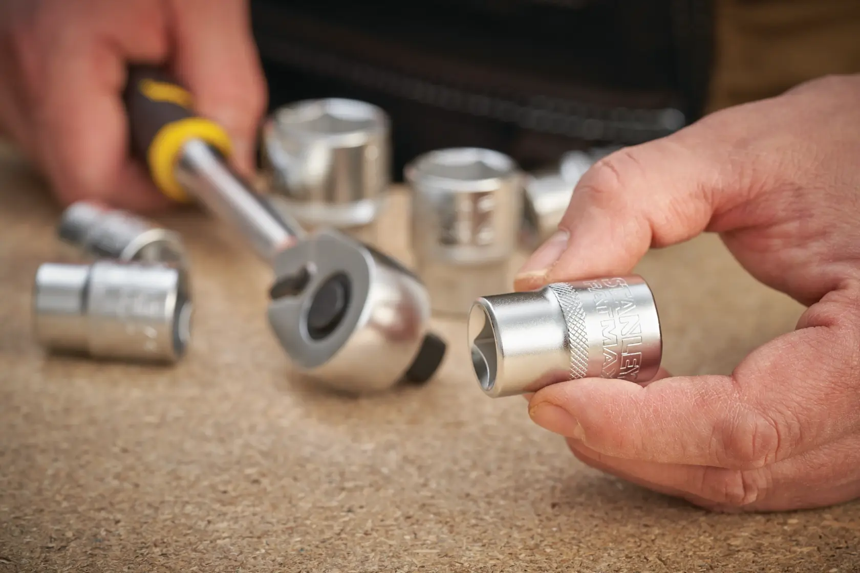 STANLEY FMMT17242-0 socket set photography, close-up of silver sockets and ratchet tool on tabletop.