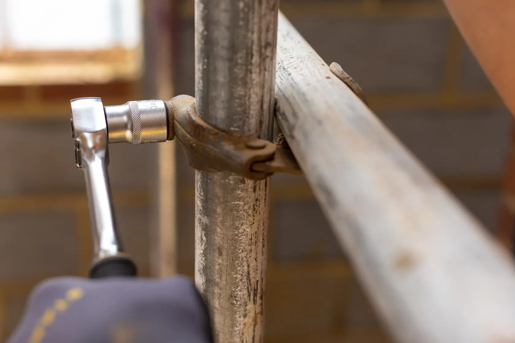 STANLEY FMMT17245-0 ratchet tool on metal pipe clamp, close-up construction context.