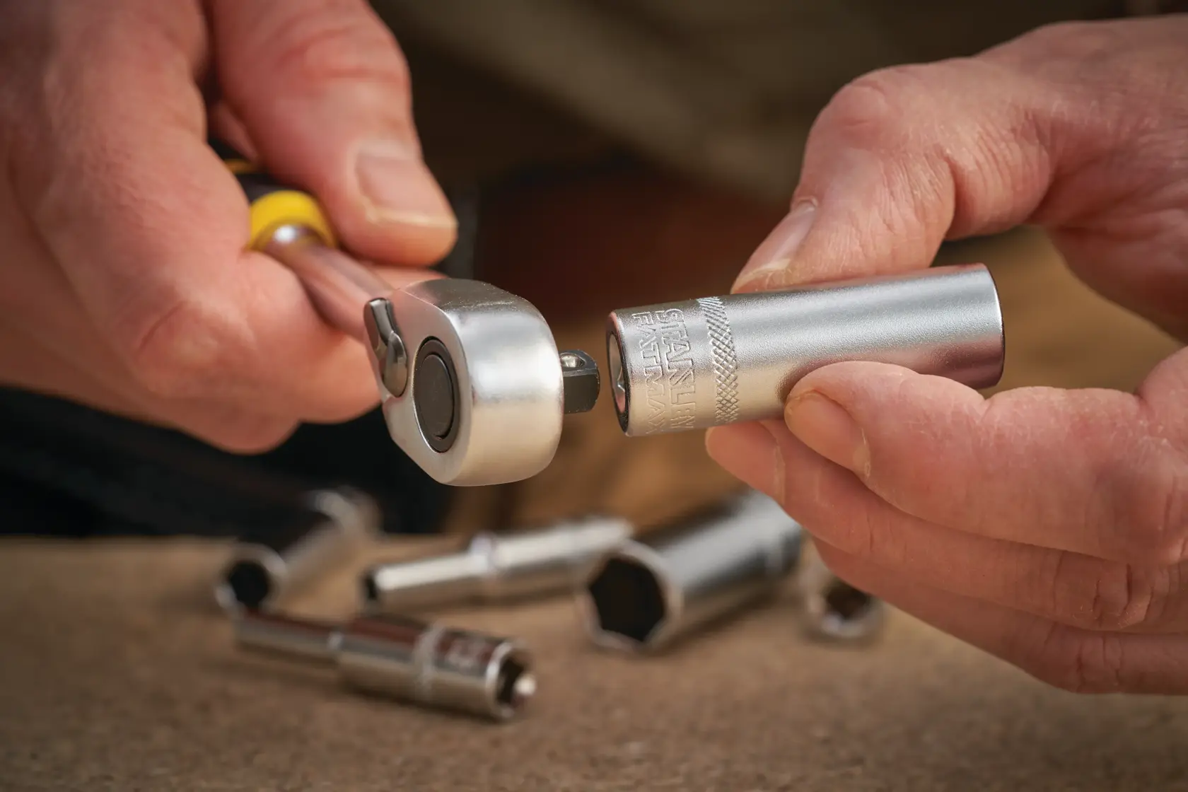 STANLEY FMMT17248-0 socket being attached to ratchet wrench, close-up, silver tool on work surface.