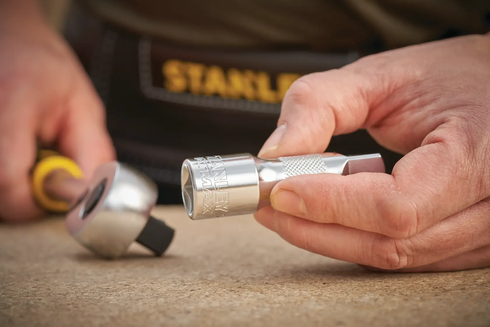Photo of STANLEY FMMT25123-0 socket and ratchet tool held in hand, silver finish, close-up view.