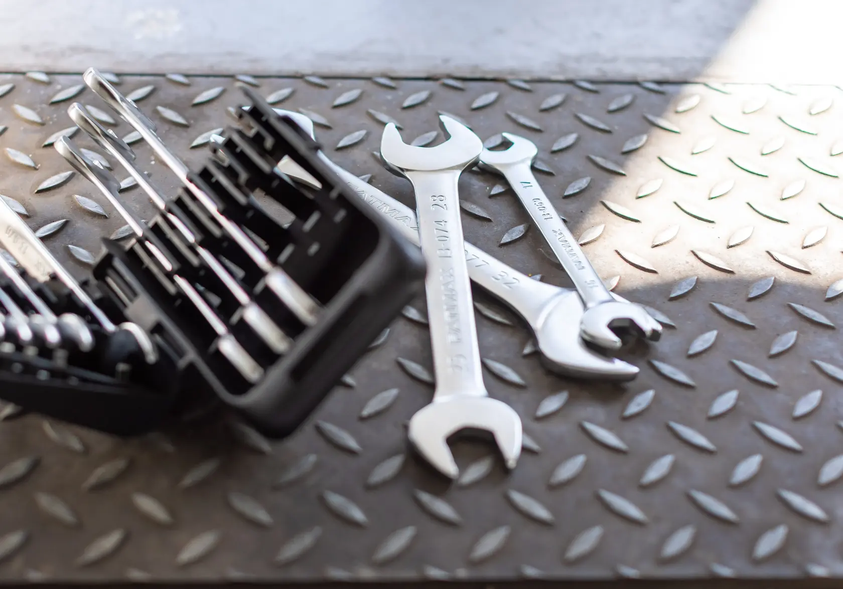 STANLEY FMMT82901-0 wrench set and open-end wrenches on textured metal surface, side angle.