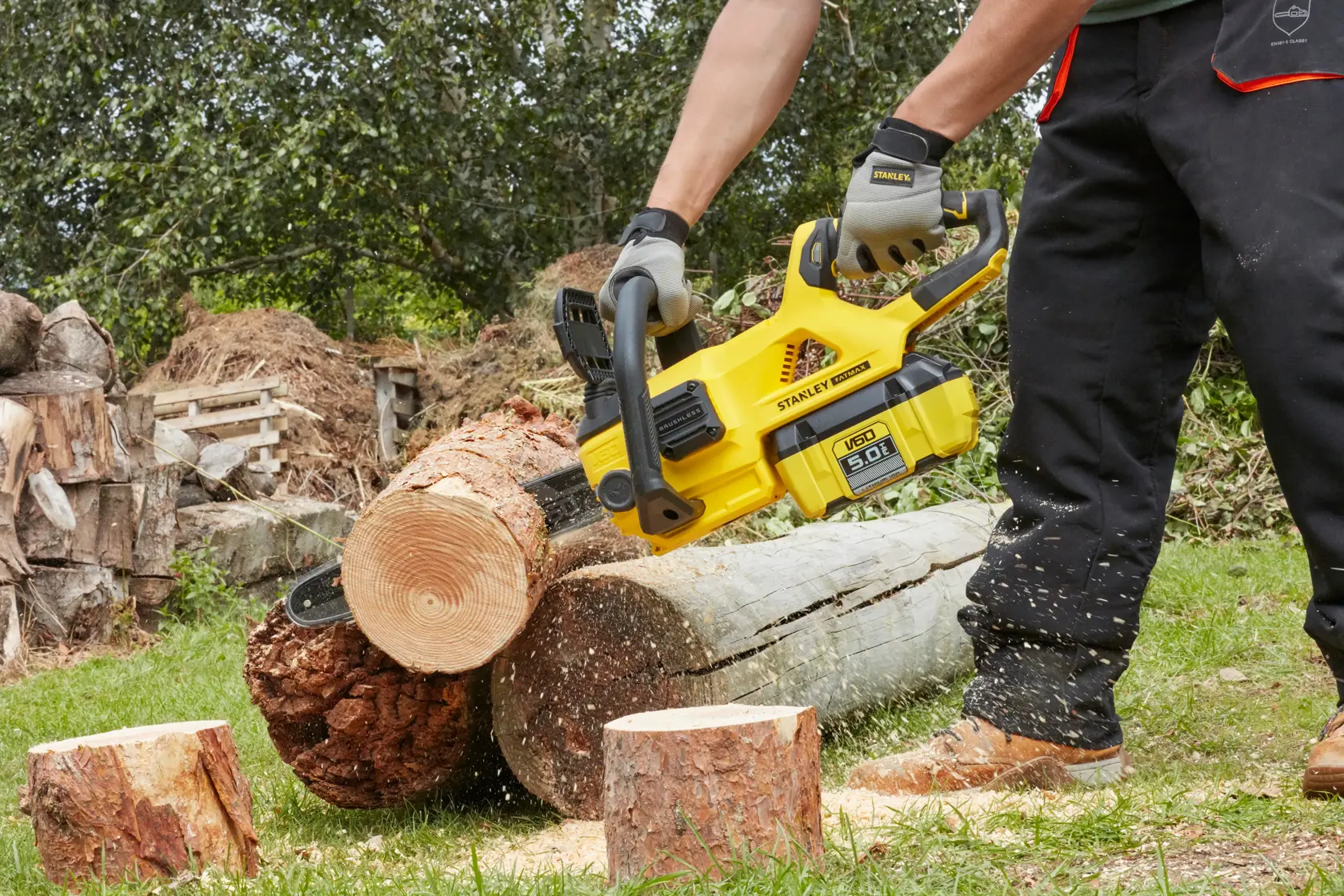 STANLEY SFMCCSB664B chainsaw cutting log outdoors, close-up action shot.