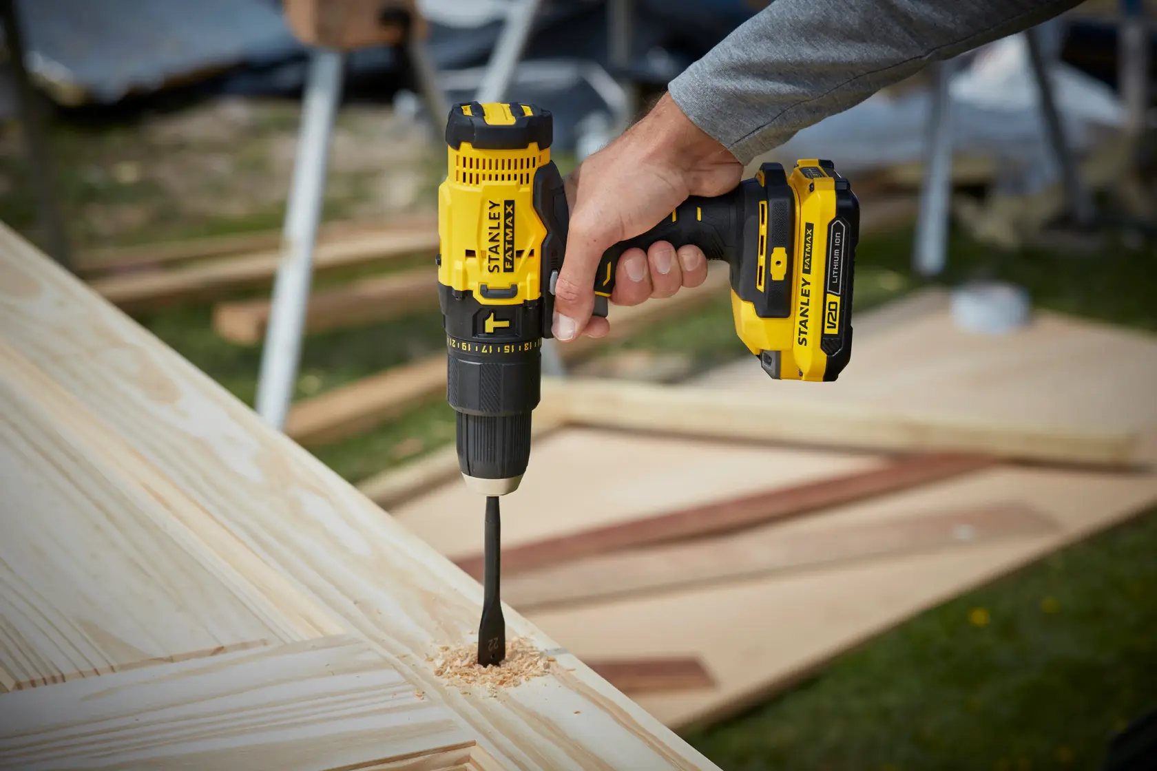 Photo of STANLEY SFMCD711C2K cordless drill used for woodworking, yellow and black design, side angle.