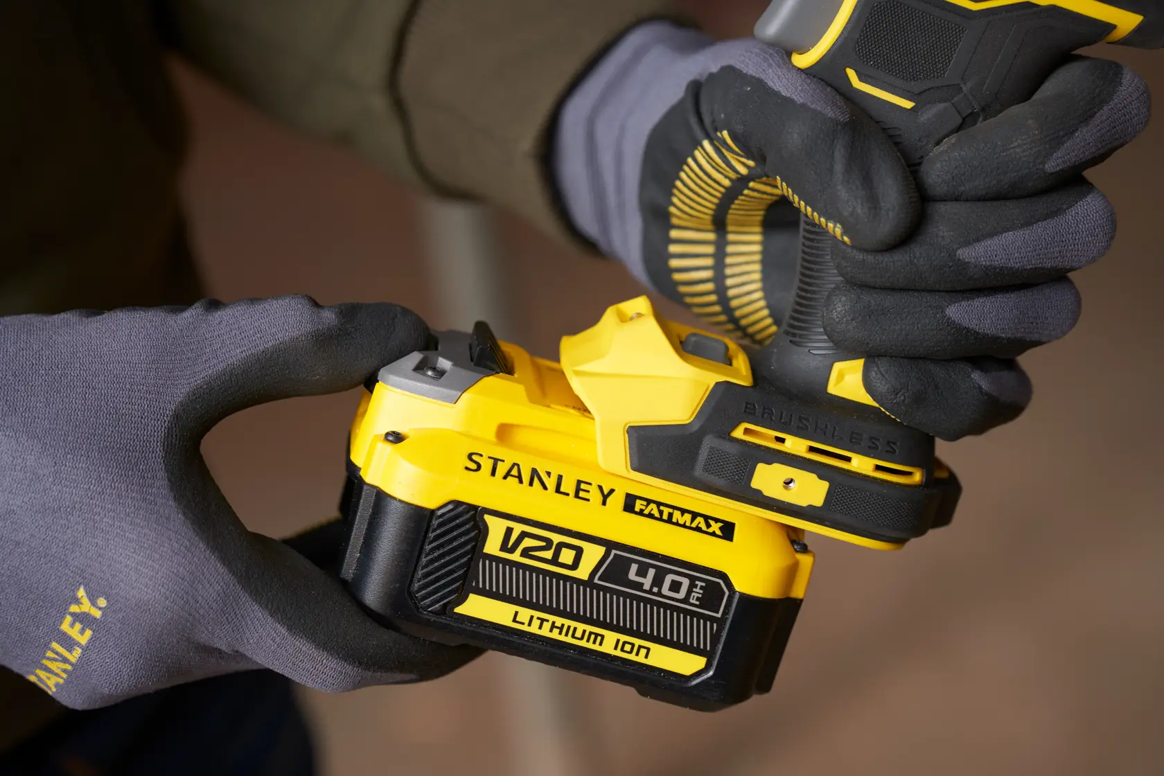 Photo of STANLEY SFMCF940M1 cordless drill with V20 4.0Ah lithium-ion battery being held with gloves.