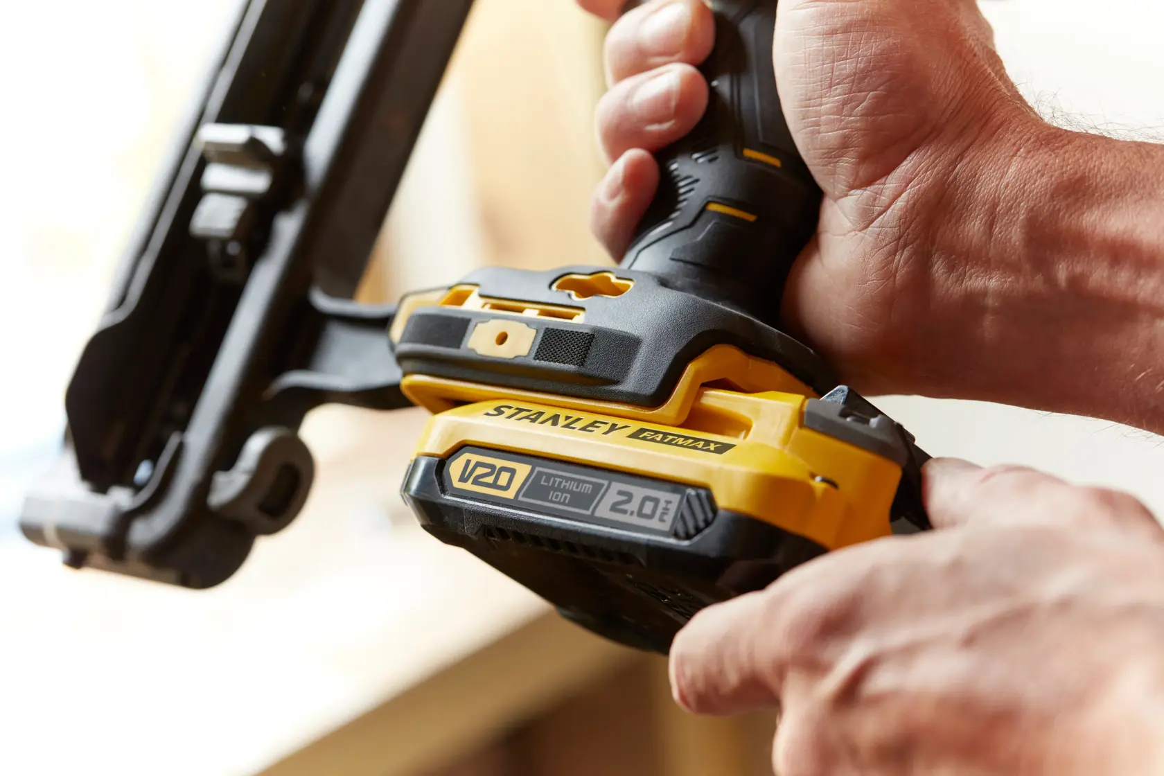 Photo of STANLEY SFMCN616D2K cordless nailer V20 with 2.0Ah lithium-ion battery held in hand.