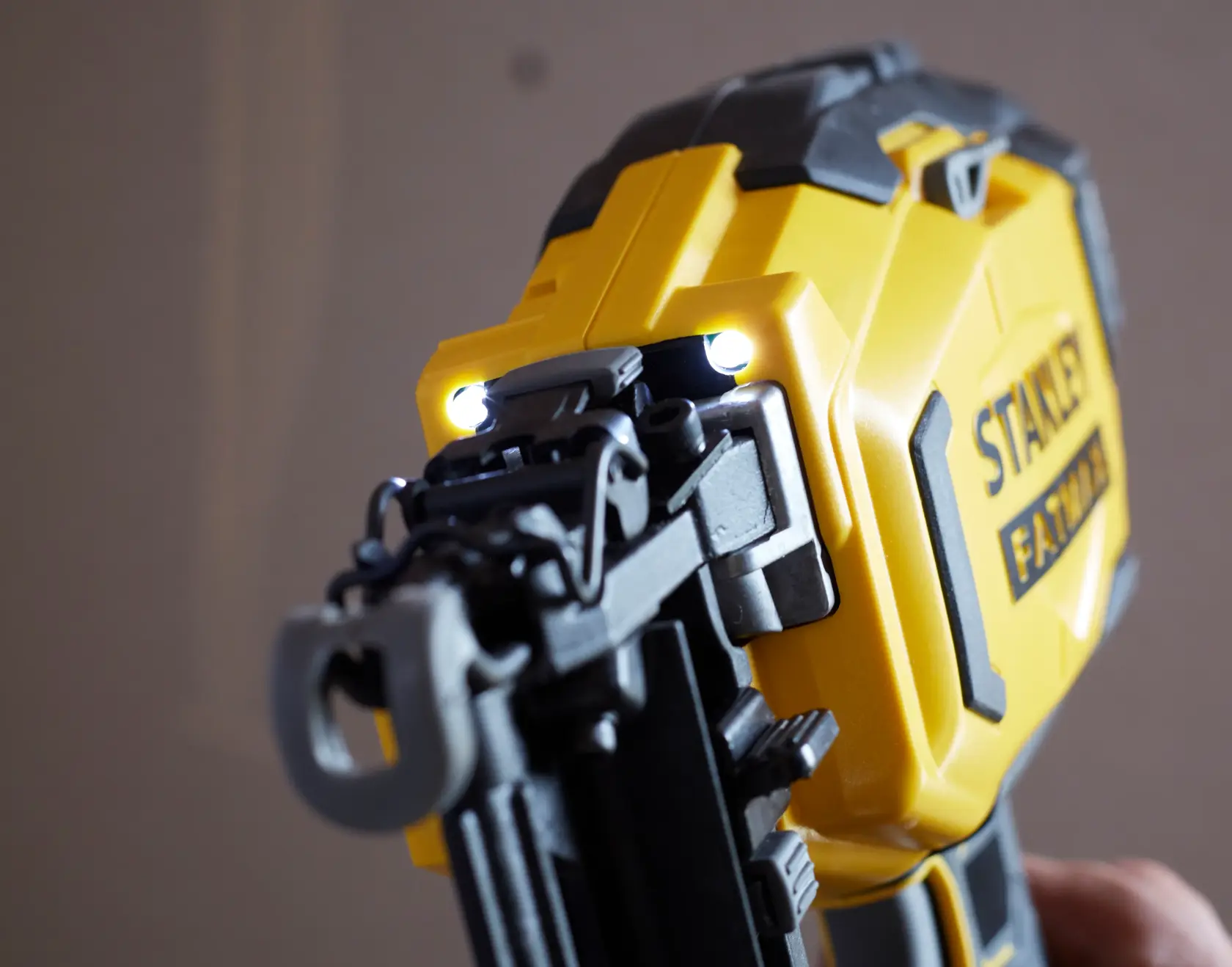 STANLEY SFMCN616D2K yellow cordless nailer with LED lights, close-up angle.