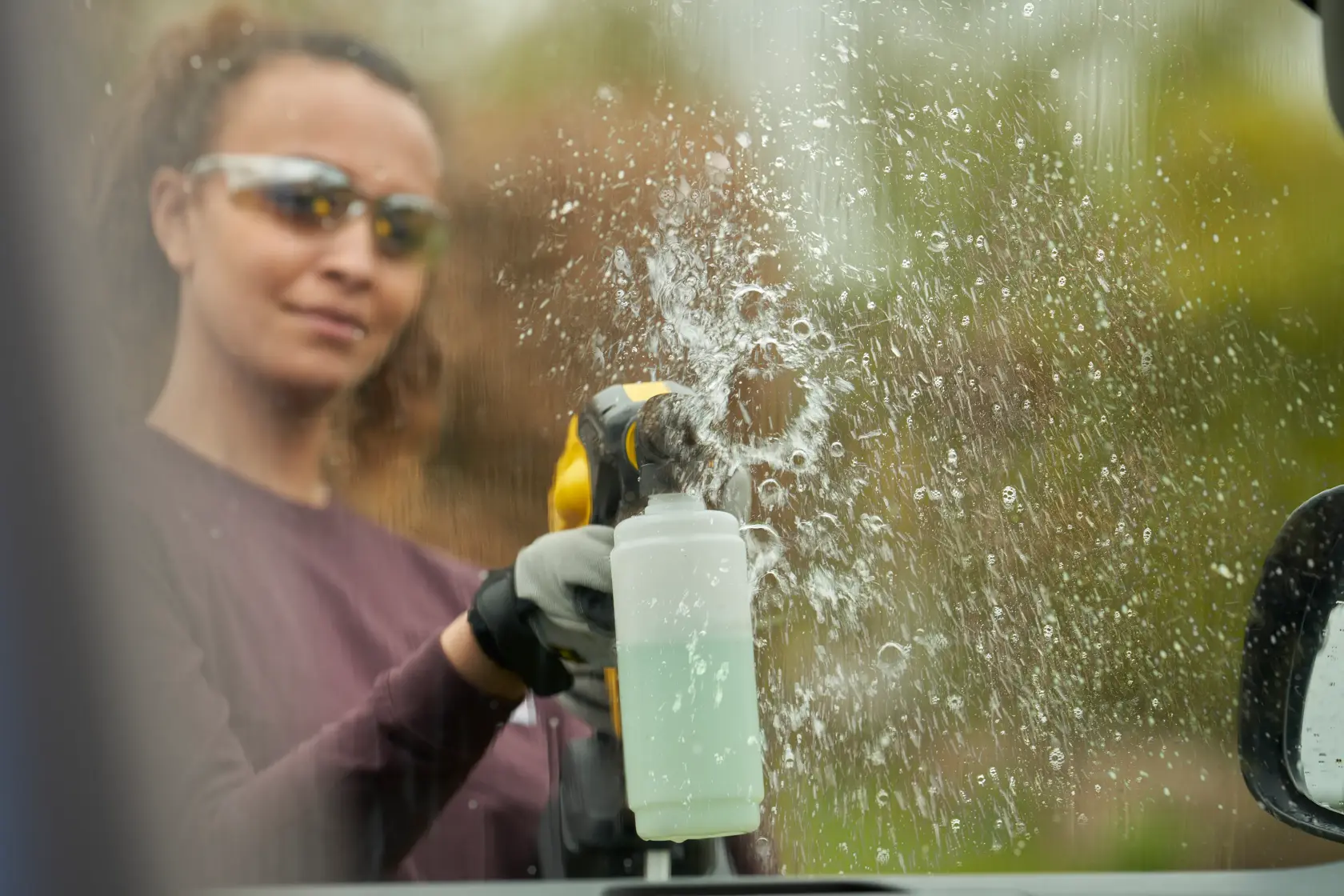 STANLEY SFMCPC93B photography of spray cleaner in use on glass window, liquid splashing clearly visible.