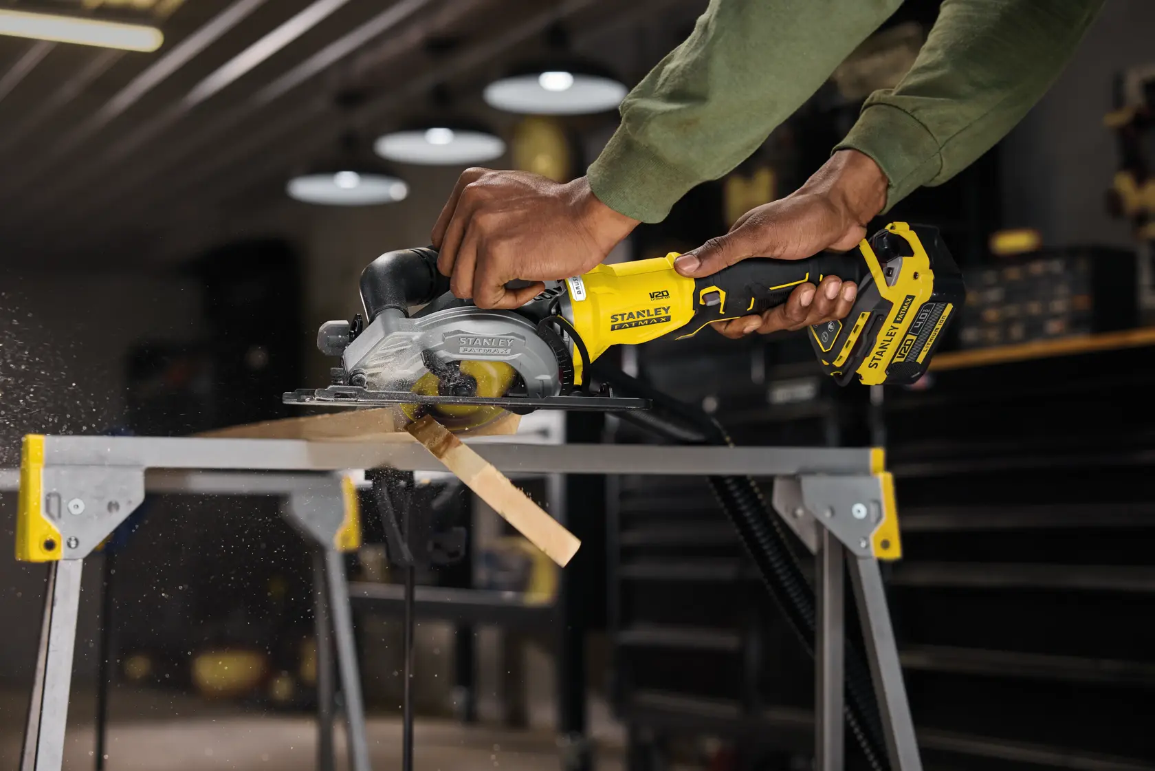 STANLEY SFMCS515B cordless circular saw cutting wood on a workbench in workshop.