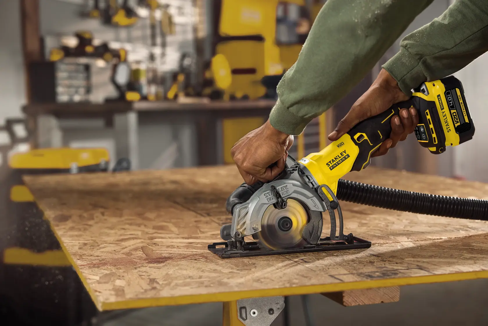 STANLEY SFMCS515B cordless circular saw in use cutting plywood, close-up in workshop setting.