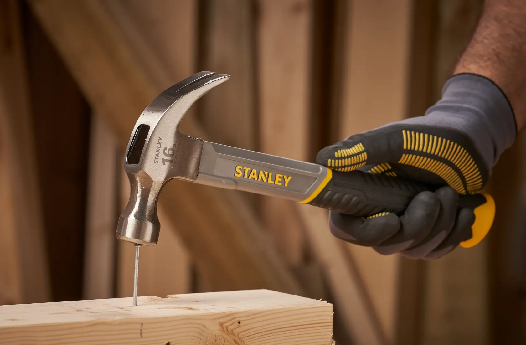 STANLEY STHT0-51309 claw hammer with black and yellow grip, side angle on white background.