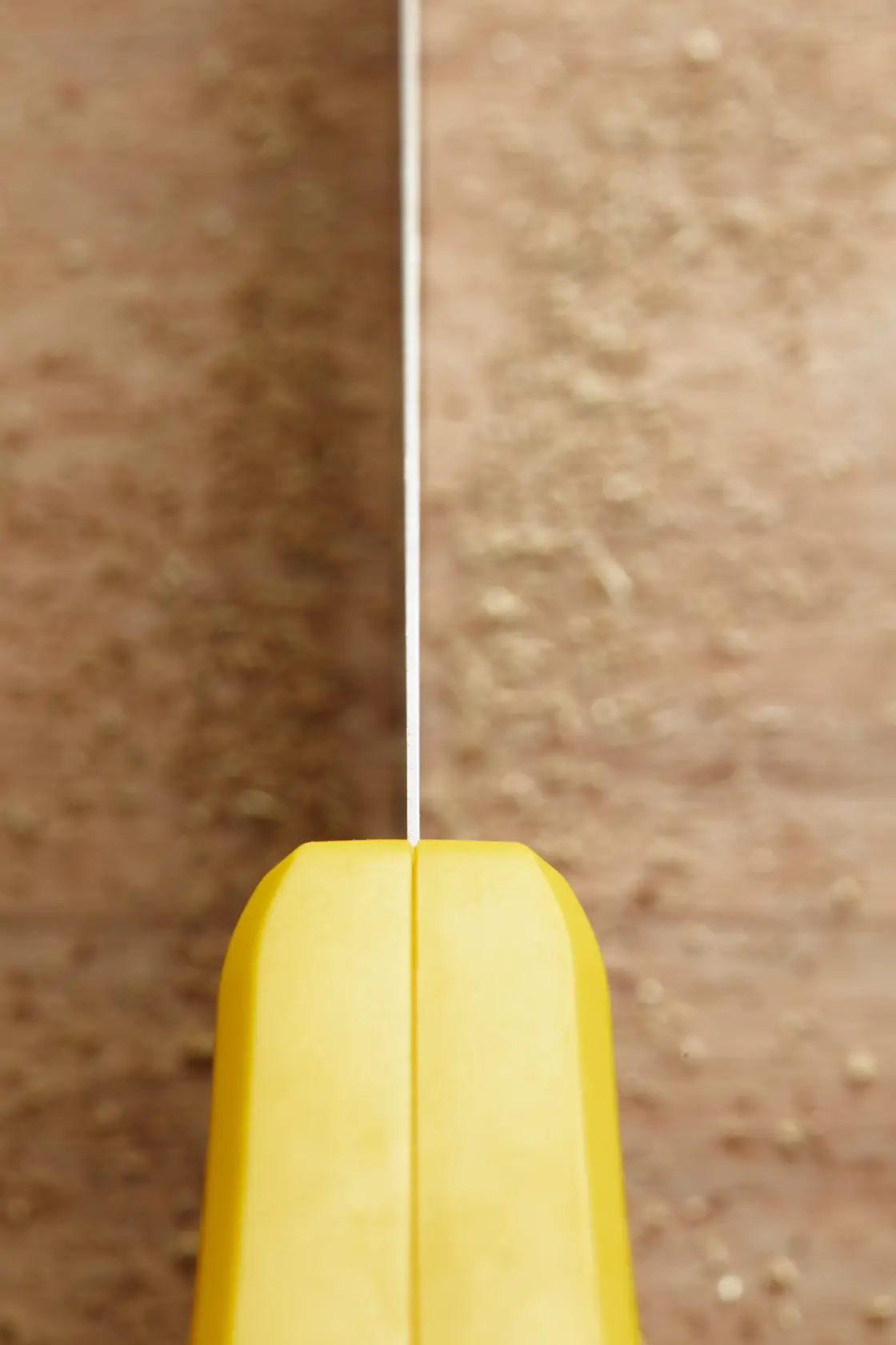 STANLEY STHT1-20352 hand saw top view with yellow handle against wooden surface.