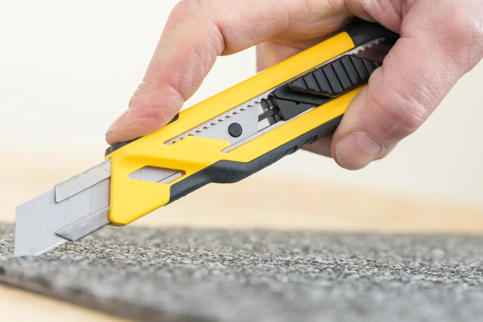 STANLEY STHT10266-0 Universalmesser Nahaufnahme schneidet Teppich, gelber und schwarzer Griff.