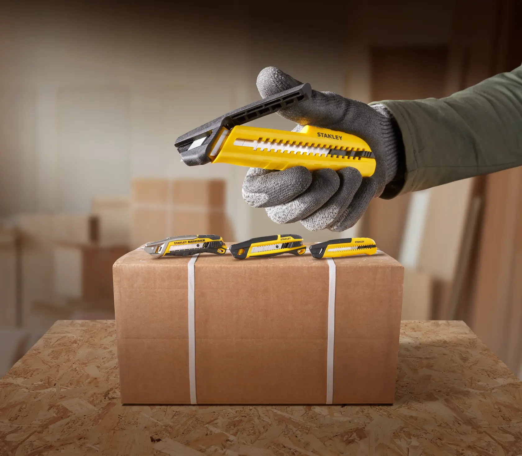 STANLEY utility knife STHT10489, STHT10489-0 yellow black on box, worker hand with glove, photography.