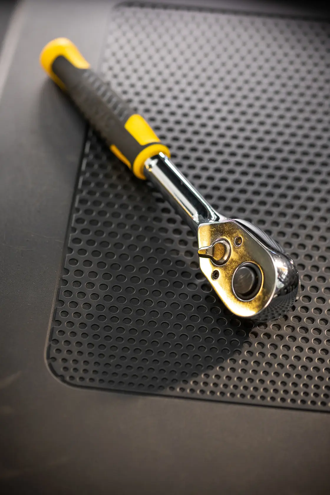 Photo of STANLEY STMT82665-0 ratchet wrench with yellow and black handle on perforated mat.