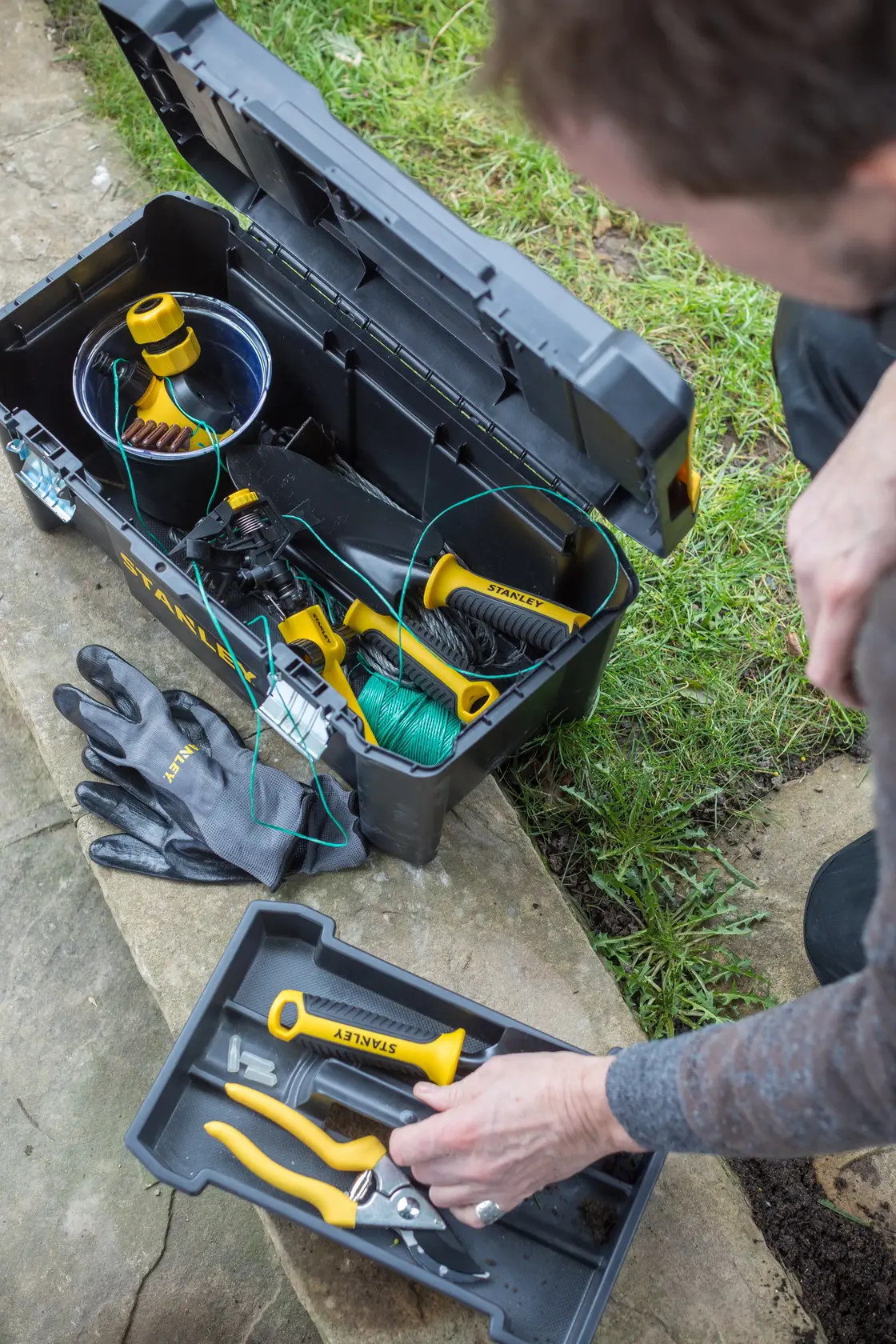 STANLEY toolbox open outdoors with gardening tools, gloves; SKUs STST1-75521, STST1-75521-KR, top angle.