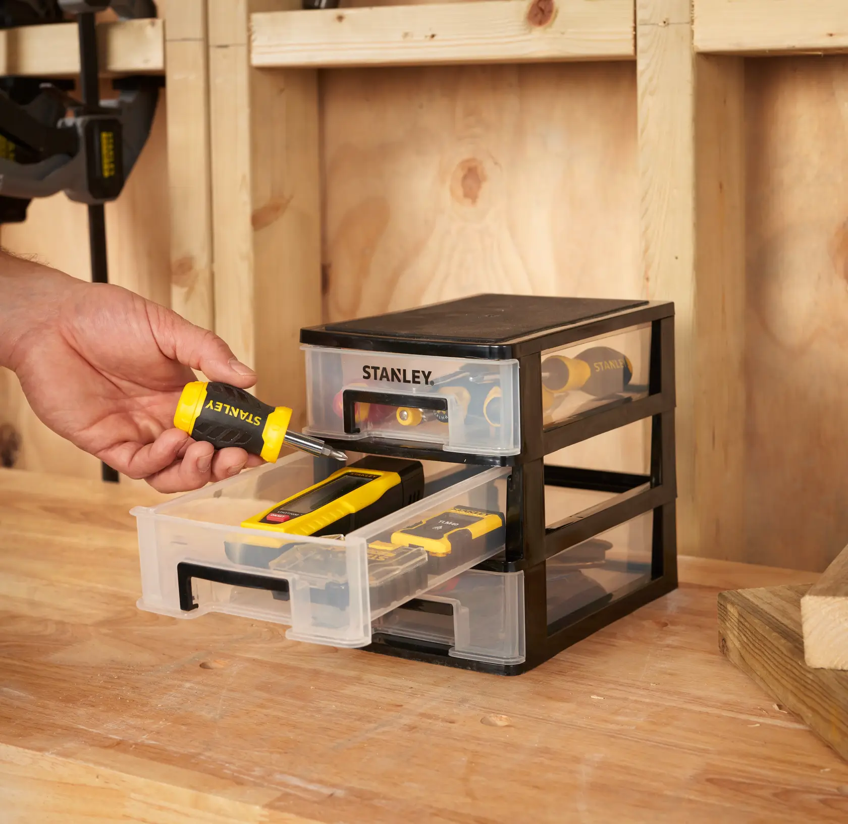 STANLEY STST40710-1 drawer organizer with three clear drawers, shown on a workbench, storing hand tools.