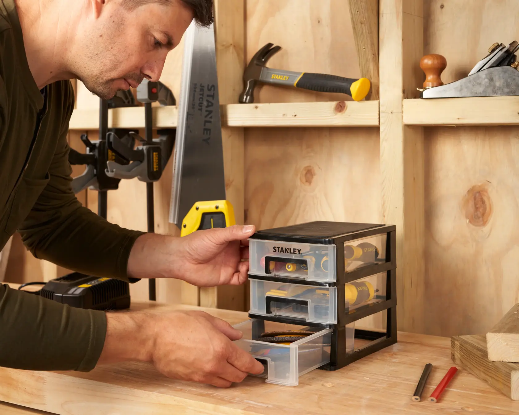 Photo of STANLEY STST40710-1 storage drawers on a workbench, filled with hand tools in a workshop.