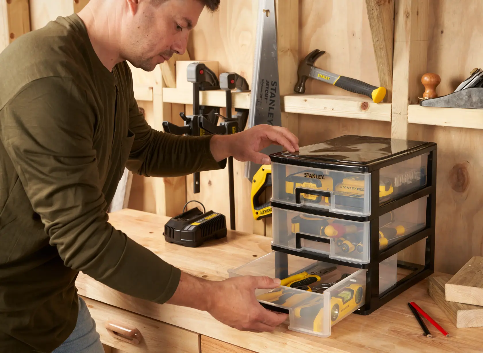 STANLEY STST40712-1 organizer with three transparent drawers on a workbench, storing hand tools.