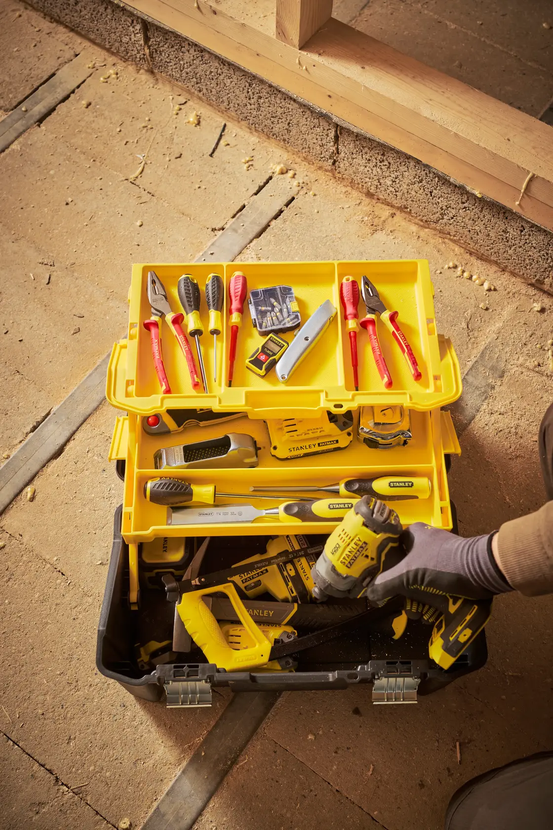 Photo of STANLEY STST83397-1 toolbox open with organized hand and power tools in yellow and black trays.