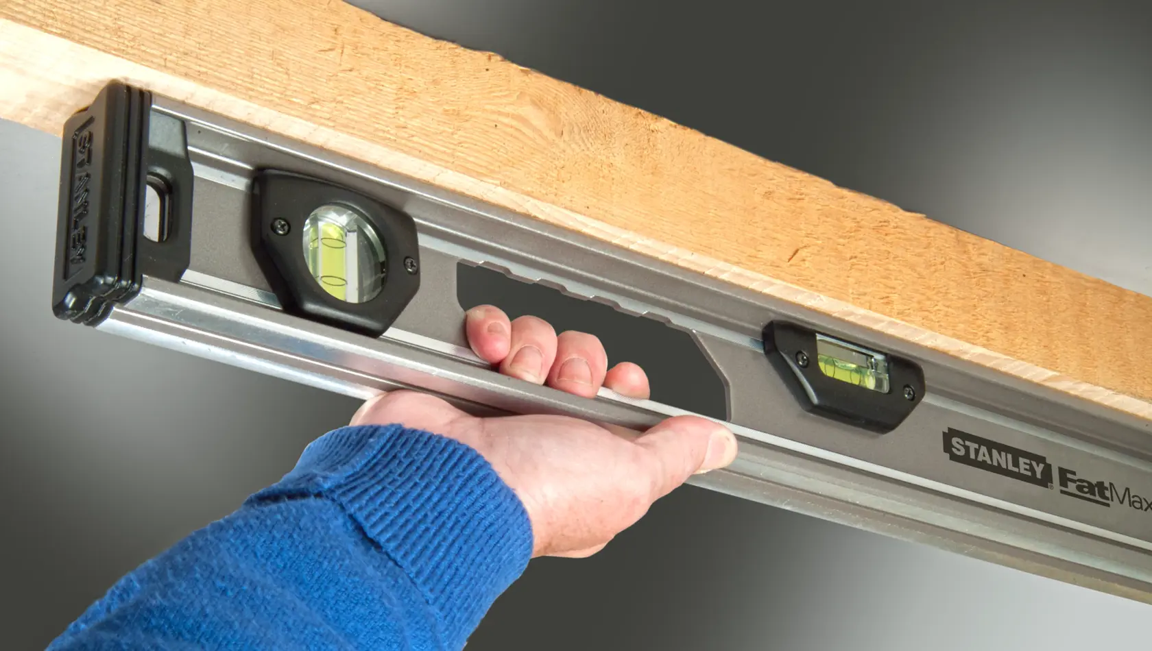 STANLEY XTHT1-42131 spirit level photography, close-up showing handle and bubble vials in use.